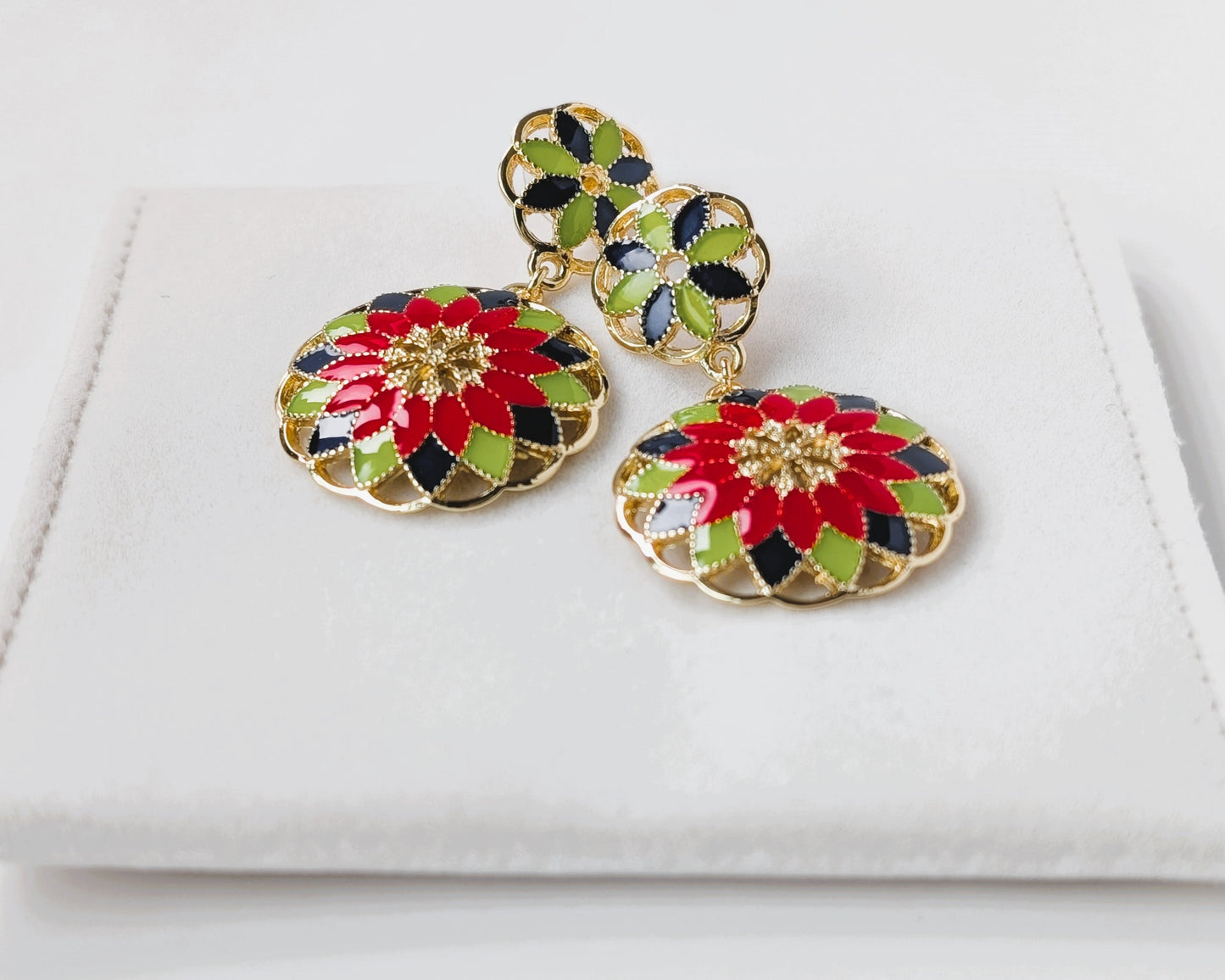 Colorful floral earrings on a white jewelry box