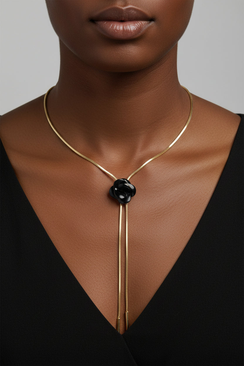 Gold necklace with a black flower pendant