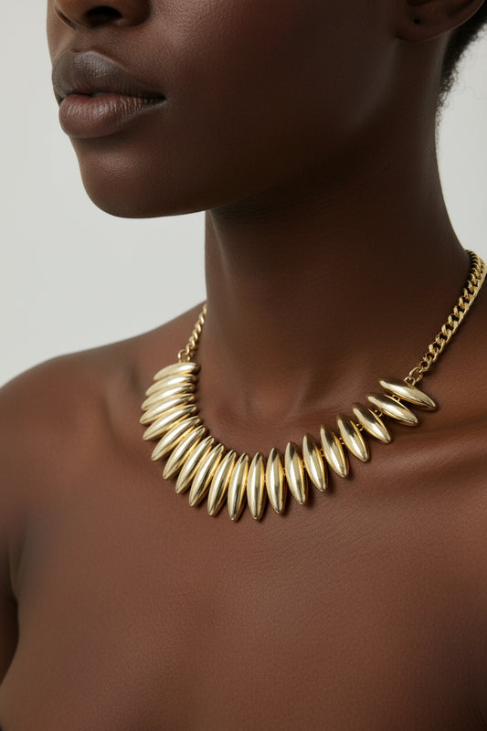 Gold necklace with a chain and spike-like design 