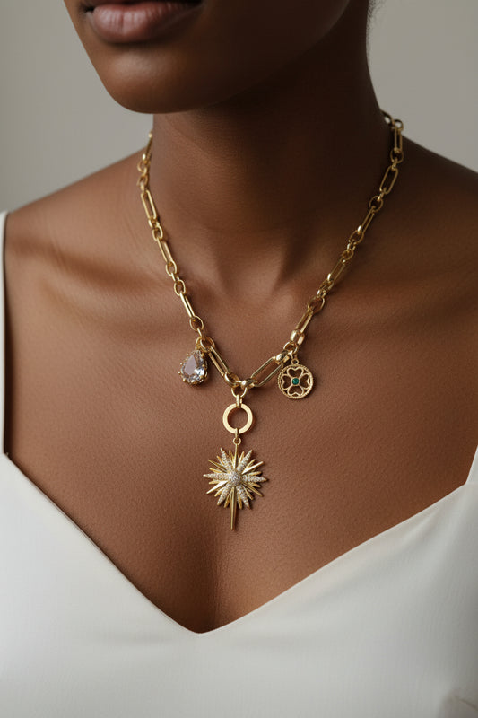 Gold necklace with star-shaped pendant and other charms 