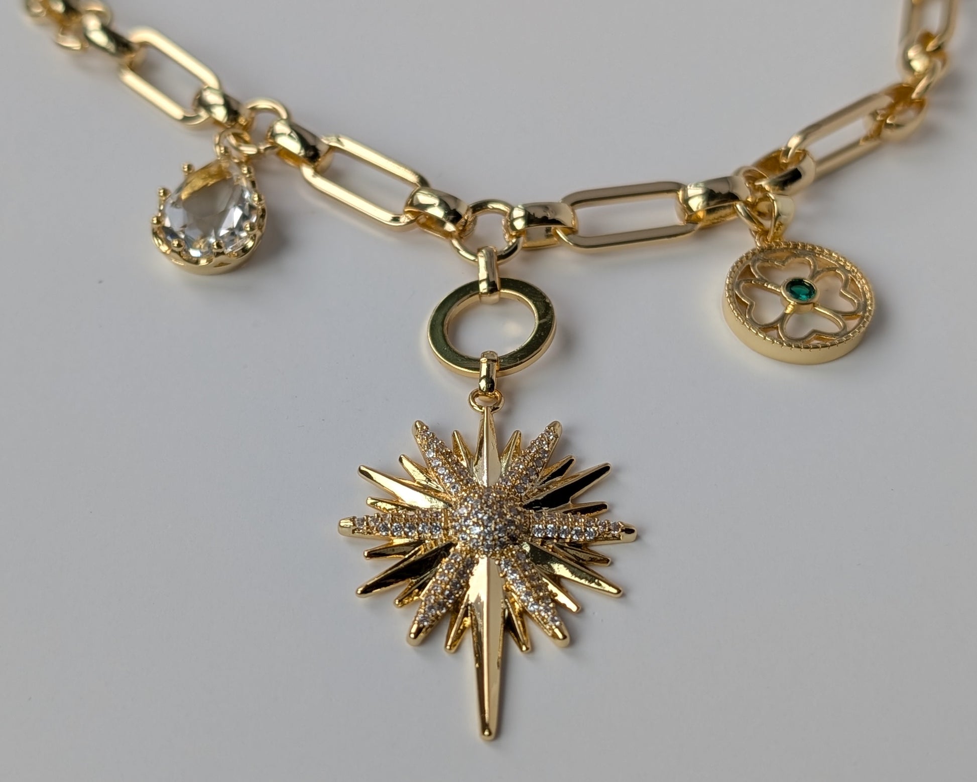 Gold necklace with star-shaped pendant and other charms