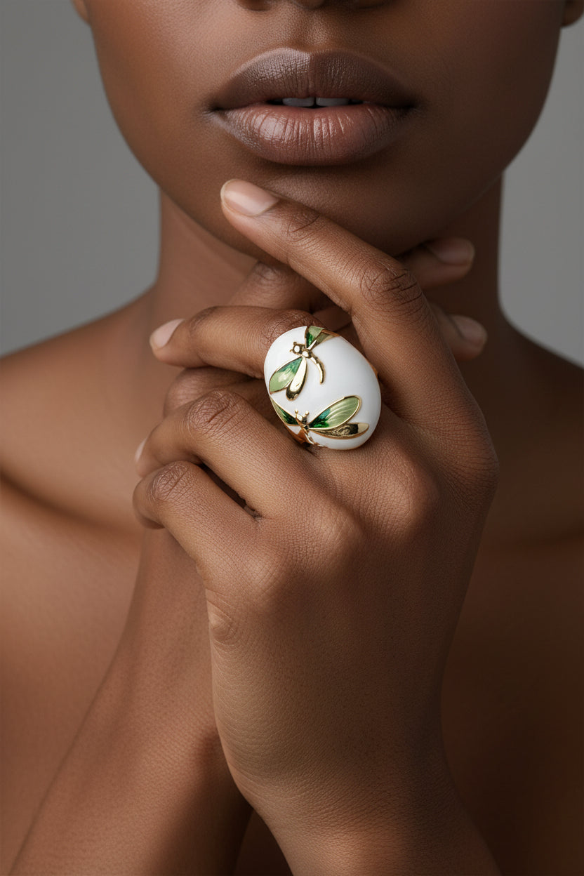 Decorative ring with a white base, gold and green dragonfly design