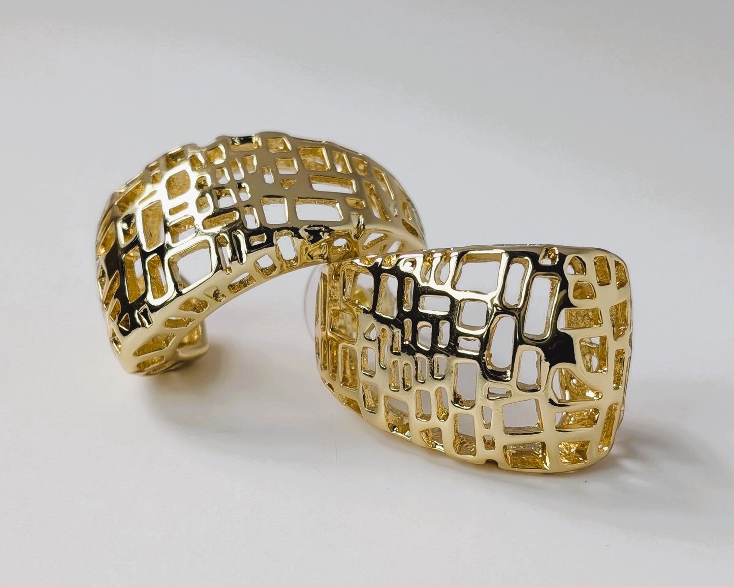 Gold bracelet with a textured pattern on a light gray background