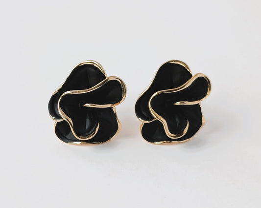Pair of black and gold earrings on a white background